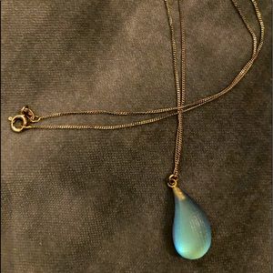 Alexis Bittar blue dew drop pendant on silver necklace.